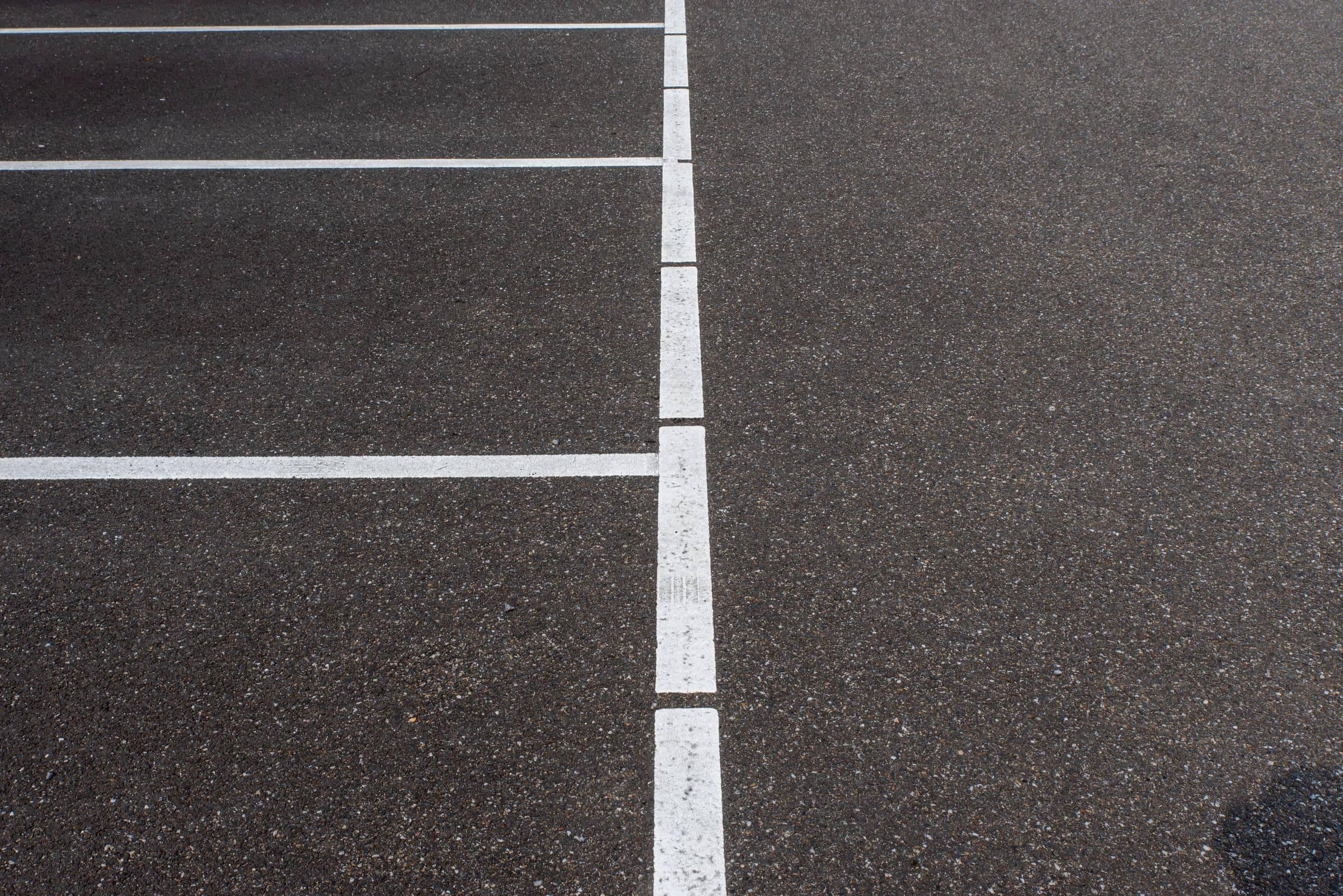 Real representative photograph of parking-space linework on asphalt